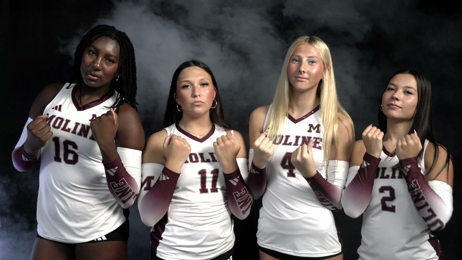 Moline Maroons volleyball players lit against black with haze during a media-day shoot